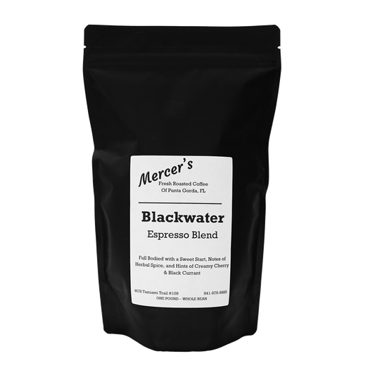 An image of a 1lb bag of whole bean freshly roasted Mercer's Blackwater Espresso Blend. The bag showcases a sleek and modern design, prominently displaying the coffee blend's name. In the background, there's a representation of a river or stream winding through dark, rich earth, symbolizing the blend's bold and deep flavors. The bag is sealed and labeled, indicating its readiness to offer a robust and intense espresso experience with a well-balanced combination of beans